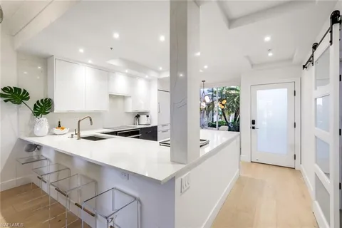 a large white kitchen with a large window