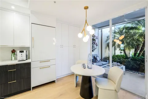 a kitchen with a sink chandelier and living room view