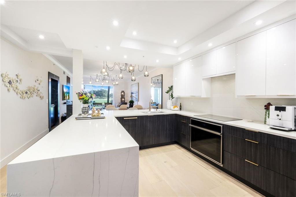 26871 Clarkston Drive, Unit 102 Bonita Springs, FL 34135 - Photo 7 of 50 a kitchen with stainless steel appliances kitchen island granite countertop a sink and cabinets