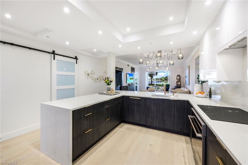 26871 Clarkston Drive, Unit 102 Bonita Springs, FL 34135 - Photo 8 of 50 a kitchen with a sink a center island stainless steel appliances and cabinets
