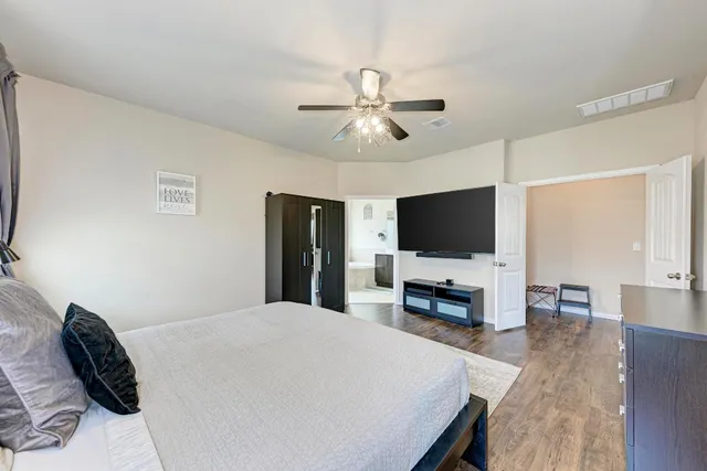 a bedroom with a bed and a flat screen tv