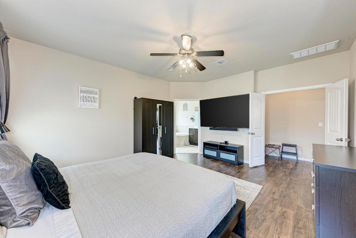 1023 Palo Duro Loop Round Rock, TX 78664 - Photo 16 of 33 Primary bedroom, with door to the en suite bathroom on the left and double doors into the entryway off the kichen