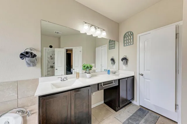 a bathroom with a double vanity sink and a mirror