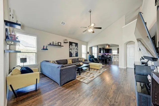 a living room with furniture and a wooden floor