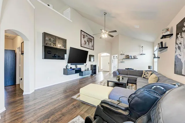 a living room with furniture a wooden floor and a flat screen tv