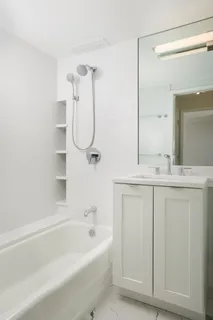 a bathroom with a granite countertop sink a toilet and shower