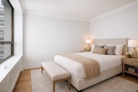 a bedroom with a bed and a potted plant