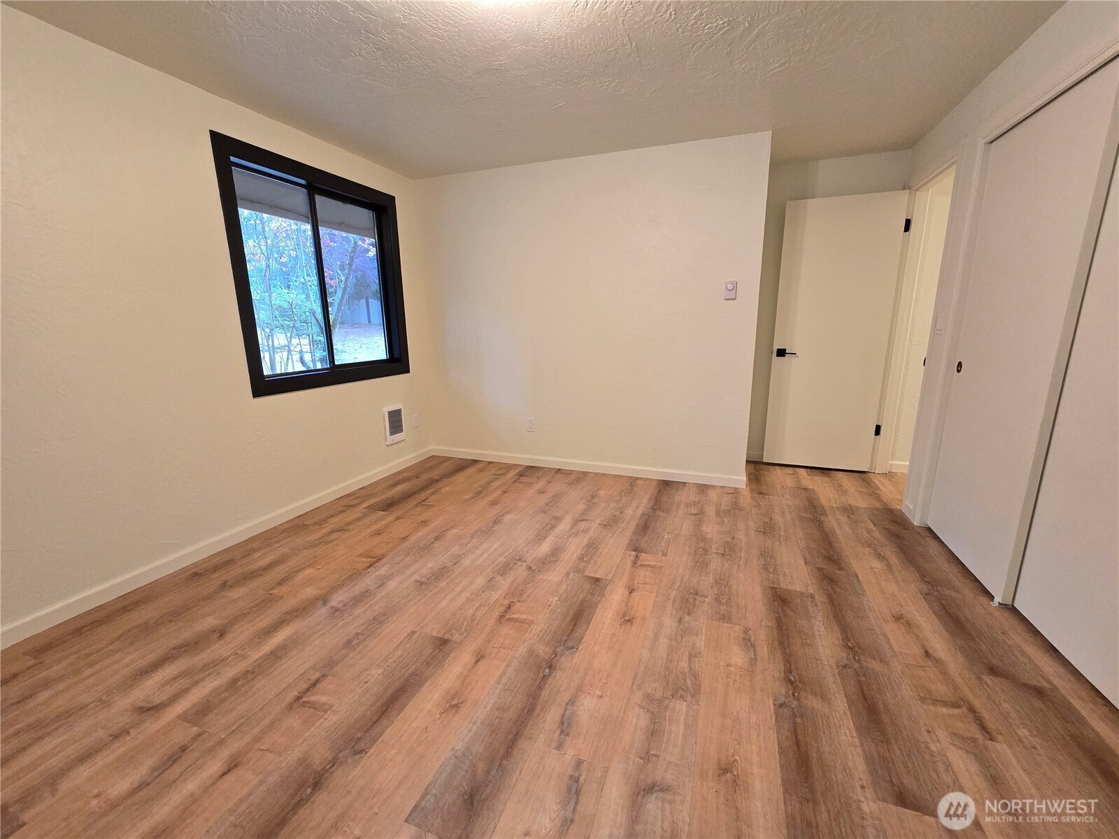 639 Lower Elwha Road Port Angeles, WA 98363 - Photo 24 of 38 a view of an empty room with wooden floor and a window