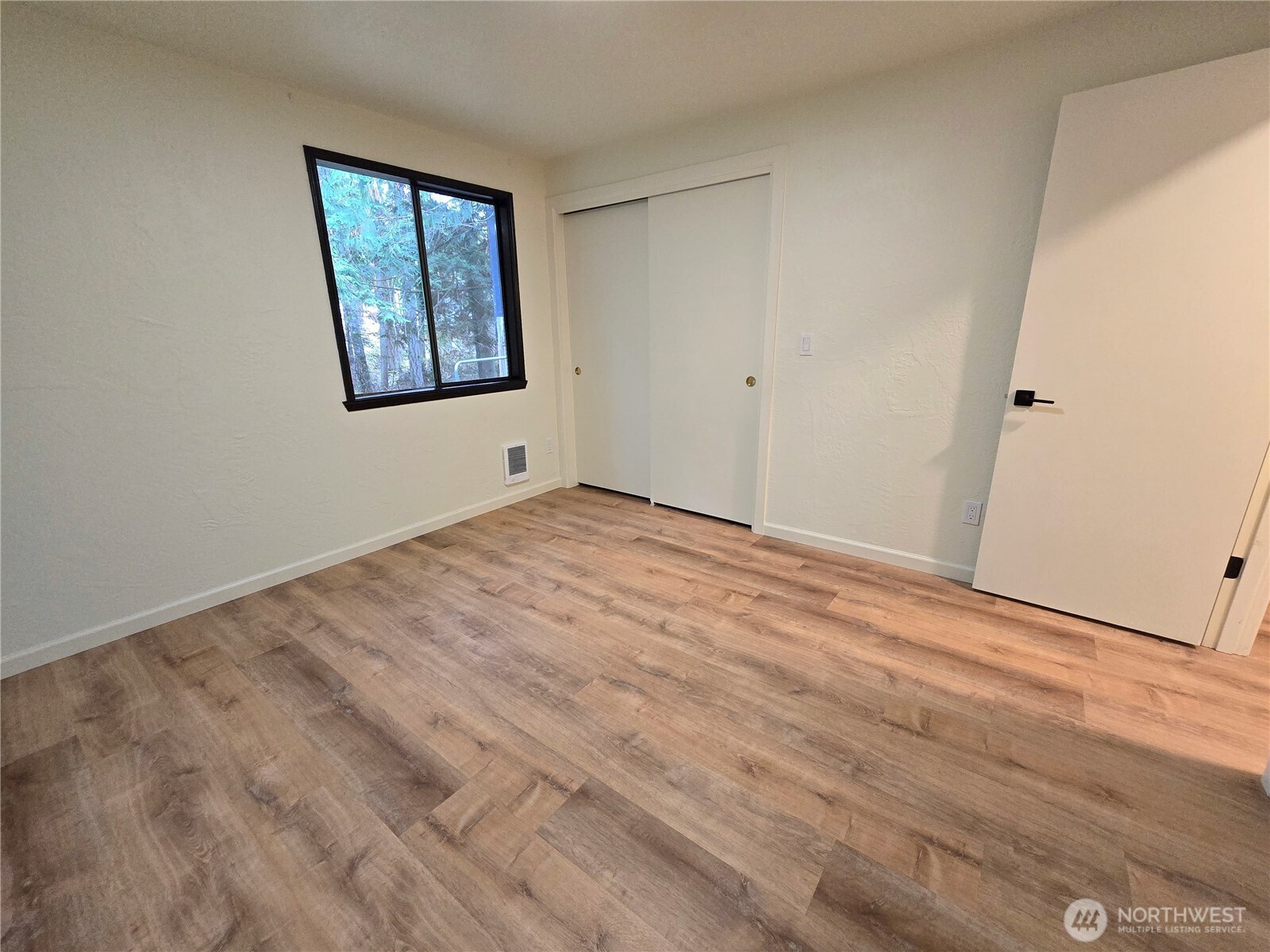 639 Lower Elwha Road Port Angeles, WA 98363 - Photo 27 of 38 a view of an empty room with wooden floor and a window