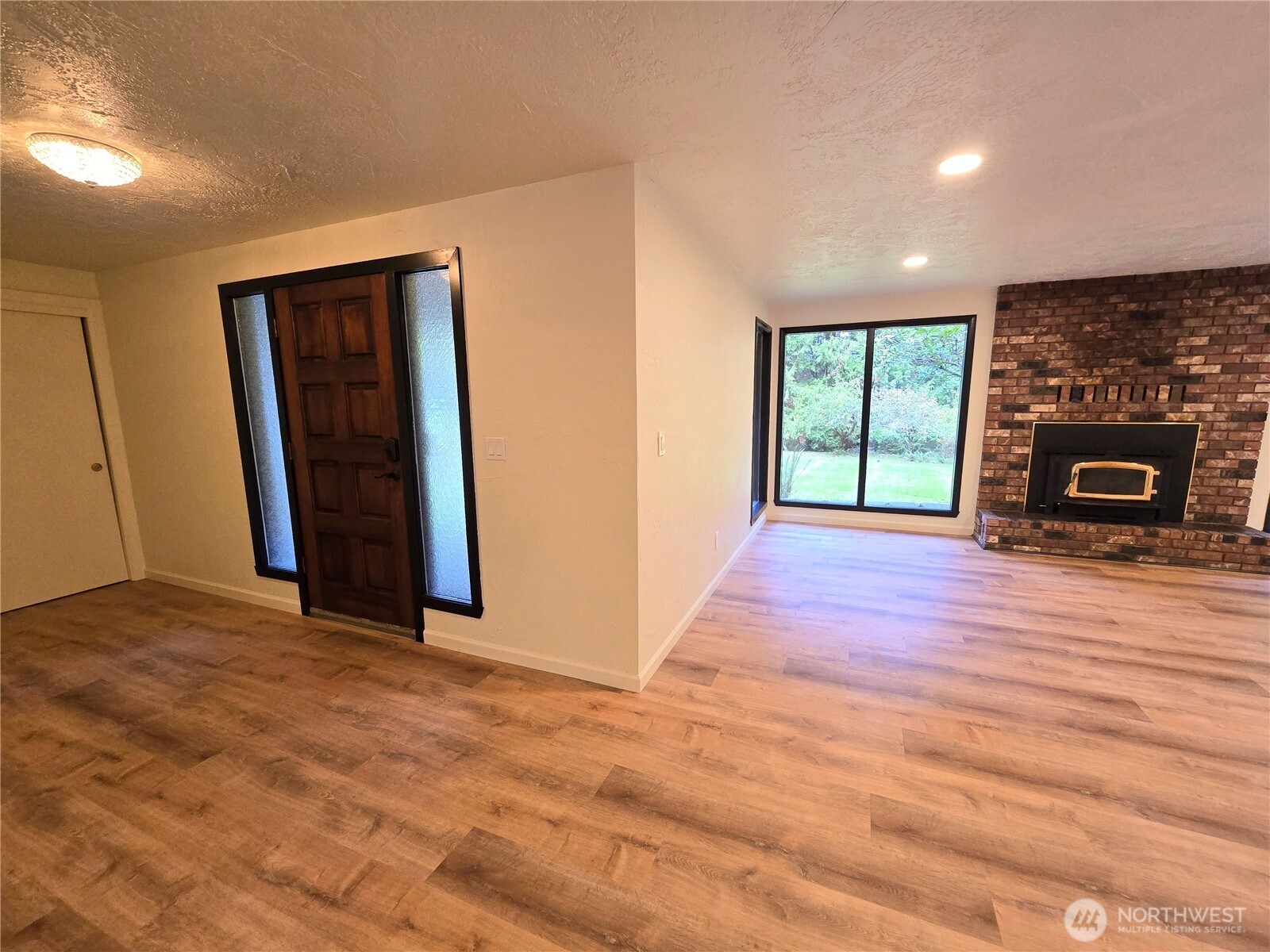 639 Lower Elwha Road Port Angeles, WA 98363 - Photo 8 of 38 a view of an empty room with wooden floor and a window