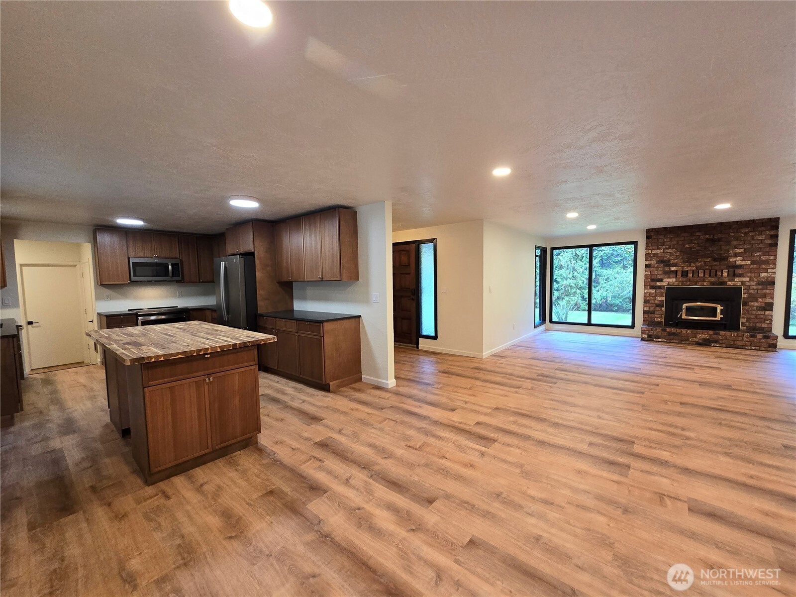 639 Lower Elwha Road Port Angeles, WA 98363 - Photo 9 of 38 a large kitchen with kitchen island a stove a refrigerator a sink and a oven with large cabinets