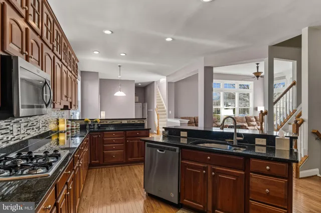 a kitchen with stainless steel appliances a sink stove and cabinets