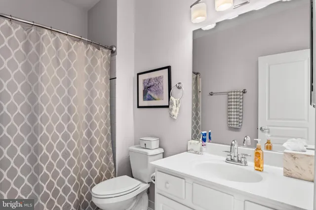 a bathroom with a sink a toilet and a mirror