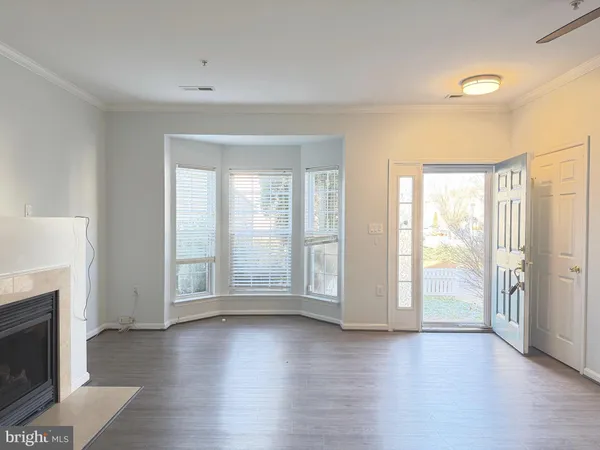 an empty room with wooden floor and fireplace