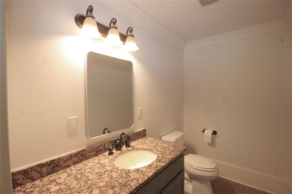 6509 Lily Trail Fairburn, GA 30213 - Photo 110 of 117 a bathroom with a granite countertop sink a toilet and a mirror