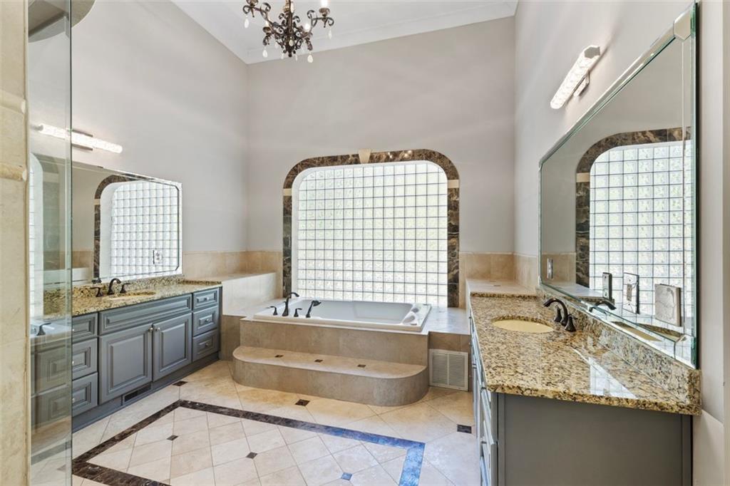 6509 Lily Trail Fairburn, GA 30213 - Photo 24 of 117 a bathroom with a granite countertop tub a double vanity sink a window and a mirror