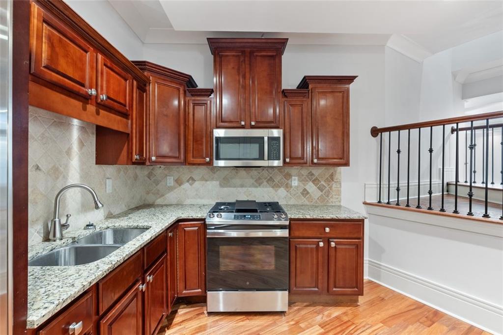 6509 Lily Trail Fairburn, GA 30213 - Photo 33 of 117 a kitchen with stainless steel appliances granite countertop wooden cabinets a stove top oven a sink and dishwasher