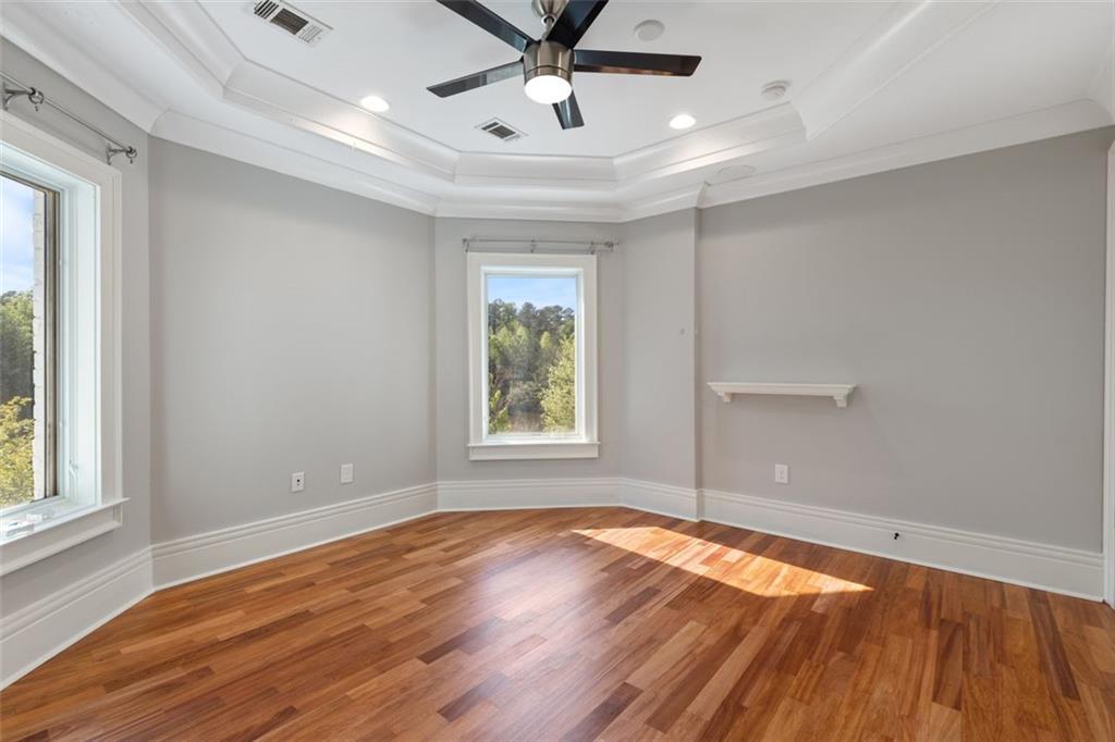 6509 Lily Trail Fairburn, GA 30213 - Photo 59 of 117 an empty room with wooden floor chandelier fan and windows