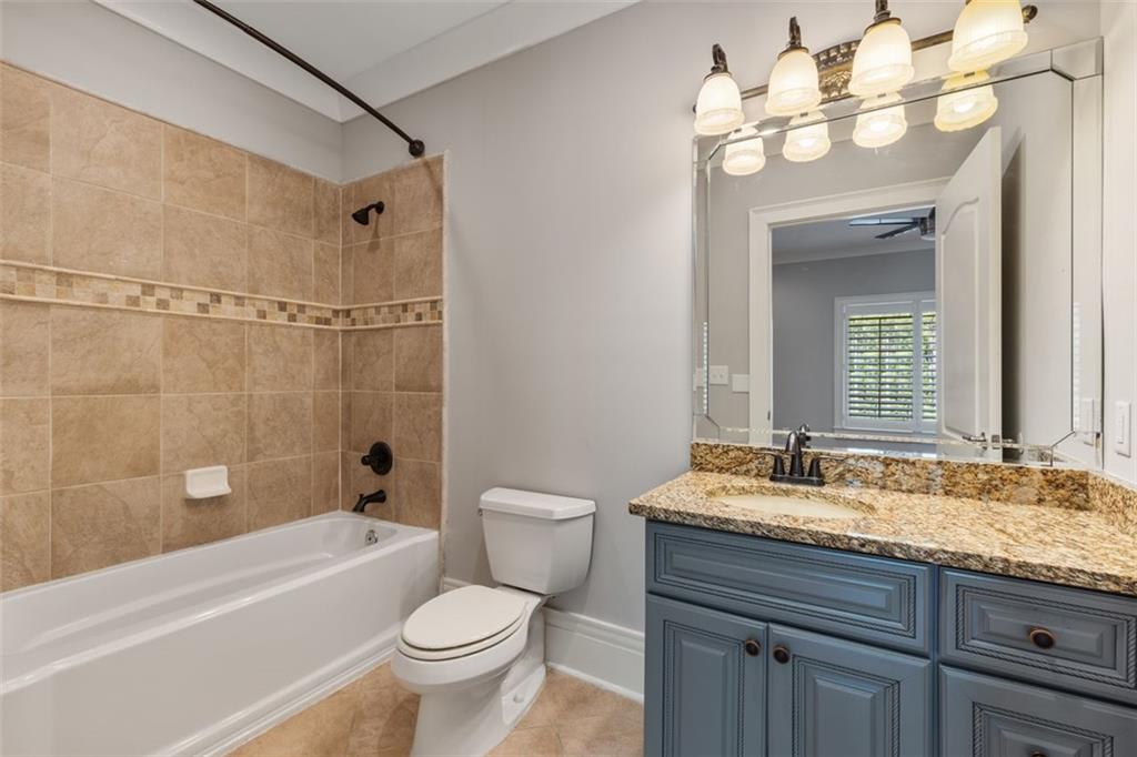 6509 Lily Trail Fairburn, GA 30213 - Photo 63 of 117 a bathroom with a granite countertop sink a toilet and shower