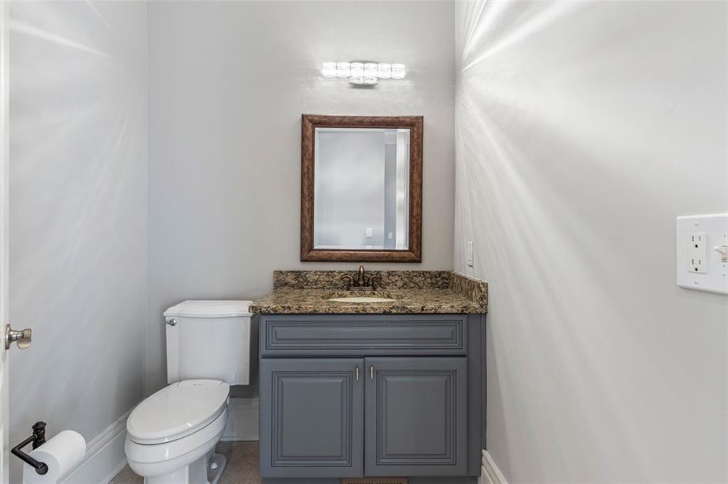 6509 Lily Trail Fairburn, GA 30213 - Photo 10 of 117 a bathroom with a granite countertop toilet a sink and mirror