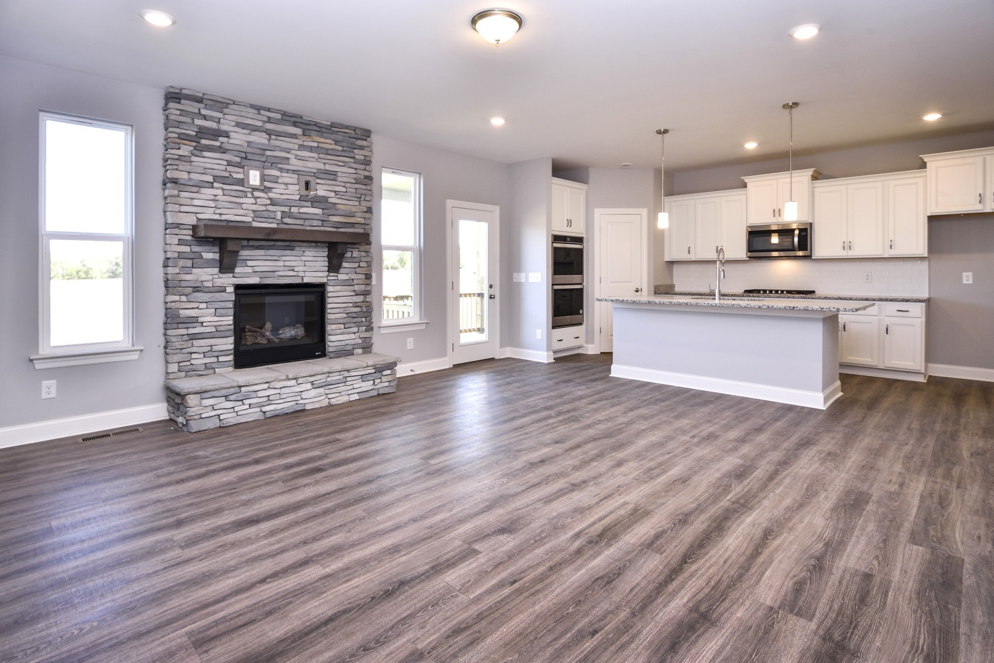 74 Remington Road Lebanon, TN 37090 - Photo 3 of 25 a large kitchen with cabinets wooden floor and a fireplace