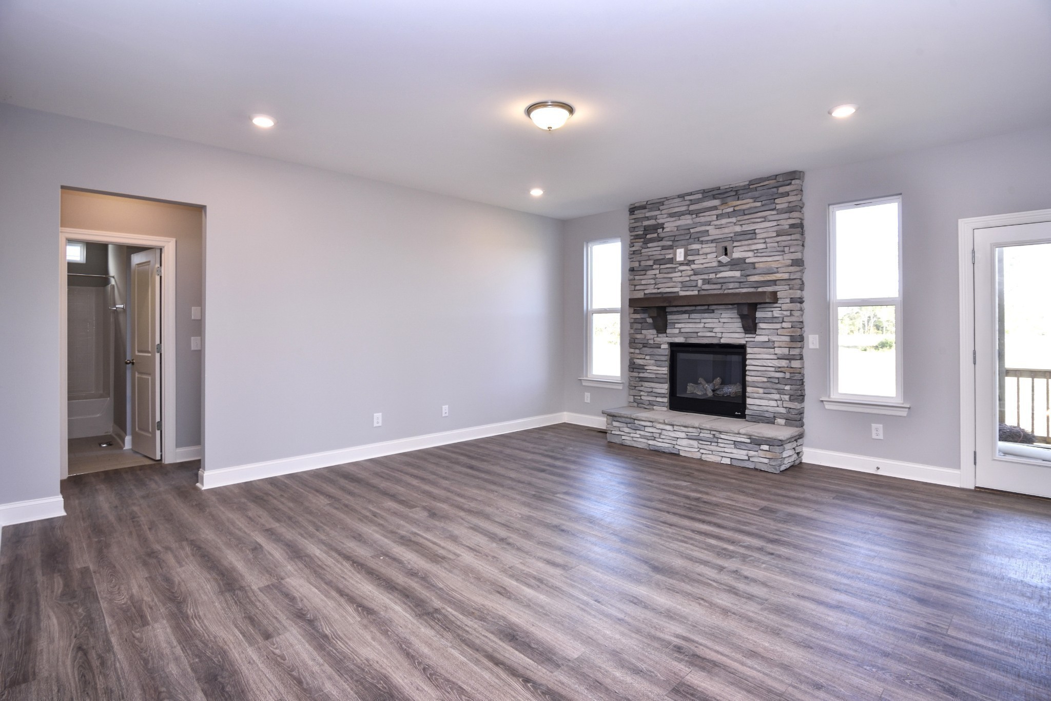 74 Remington Road Lebanon, TN 37090 - Photo 4 of 25 an empty room with wooden floor fireplace and windows