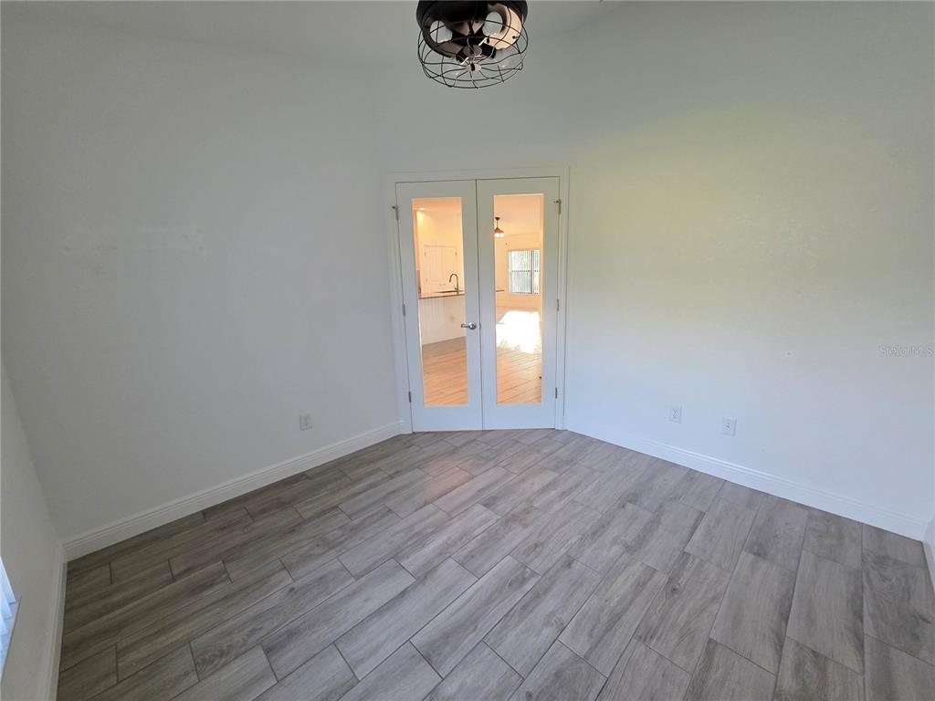 11240 Marvelwood Road Weeki Wachee, FL 34614 - Photo 15 of 21 an empty room with wooden floor and windows