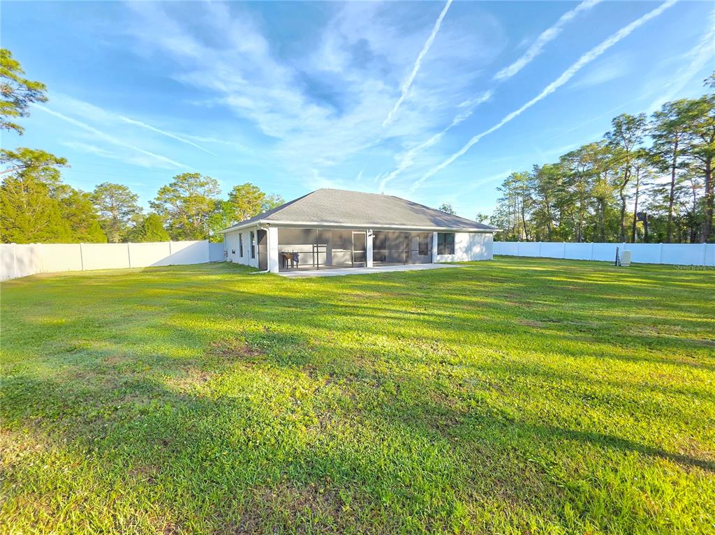 11240 Marvelwood Road Weeki Wachee, FL 34614 - Photo 20 of 21 a view of a large pool with a table and chairs under an umbrella