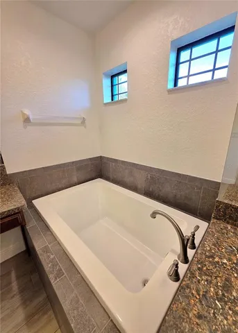 a bath tub sitting in a bathroom next to a window