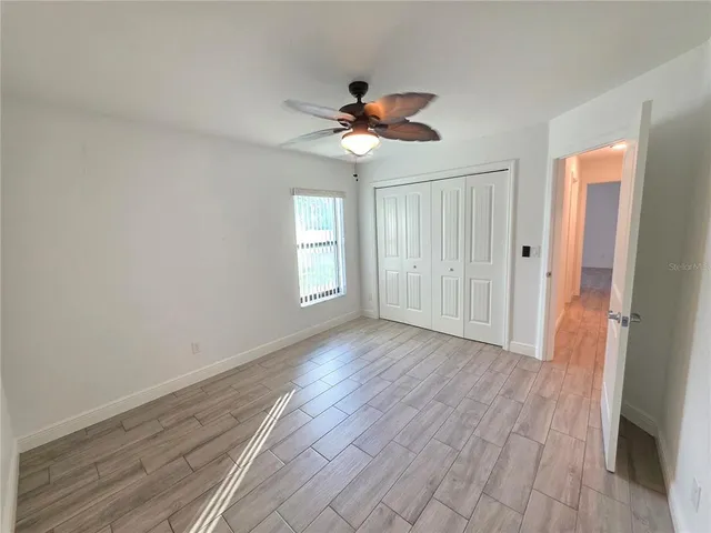 a view of a livingroom with a ceiling fan window and wooden floor