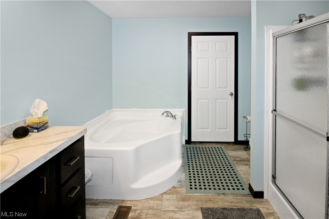 1609 Coldwater Crossing Road Lakeside Marblehead, OH 43440 - Photo 29 of 38 Bathroom with vanity, separate shower and tub, and hardwood / wood-style flooring