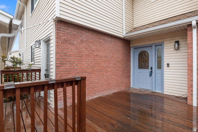 1089 East 8320th Street South, Unit 22 Sandy, UT 84094 - Photo 1 of 1 View of exterior entry featuring brick siding and a wooden deck