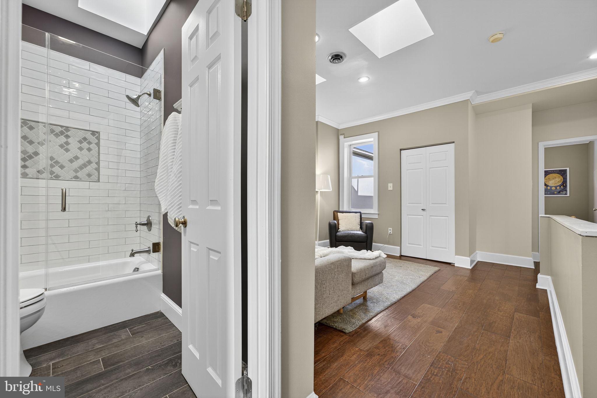 1218 G Street Southeast Washington, DC 20003 - Photo 29 of 37 a view of a bathroom with a tub shower and hardwood floor