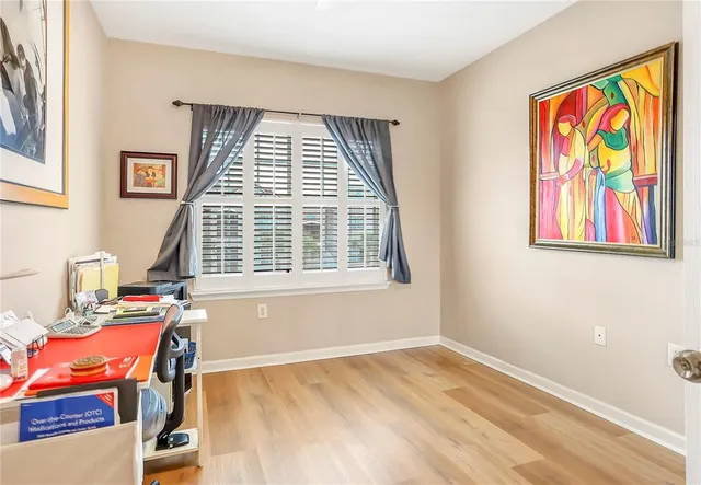 a view of a workspace with furniture and a window