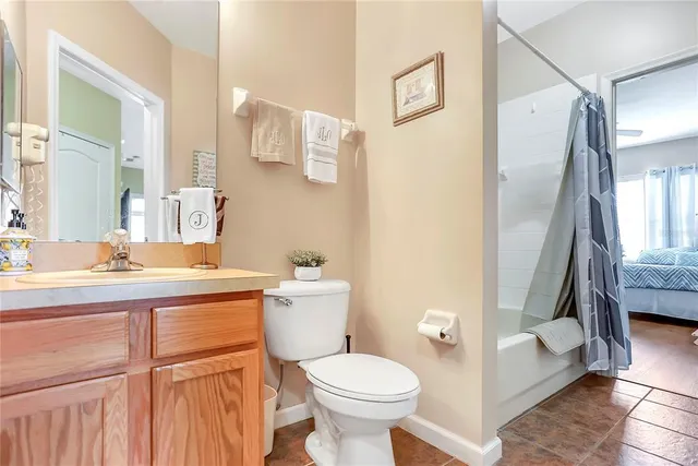 a bathroom with a granite countertop toilet sink and mirror