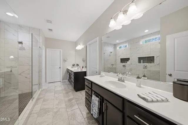 a large bathroom with a double vanity sink a mirror and shower