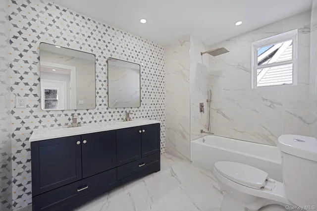 a bathroom with a sink vanity mirror and toilet
