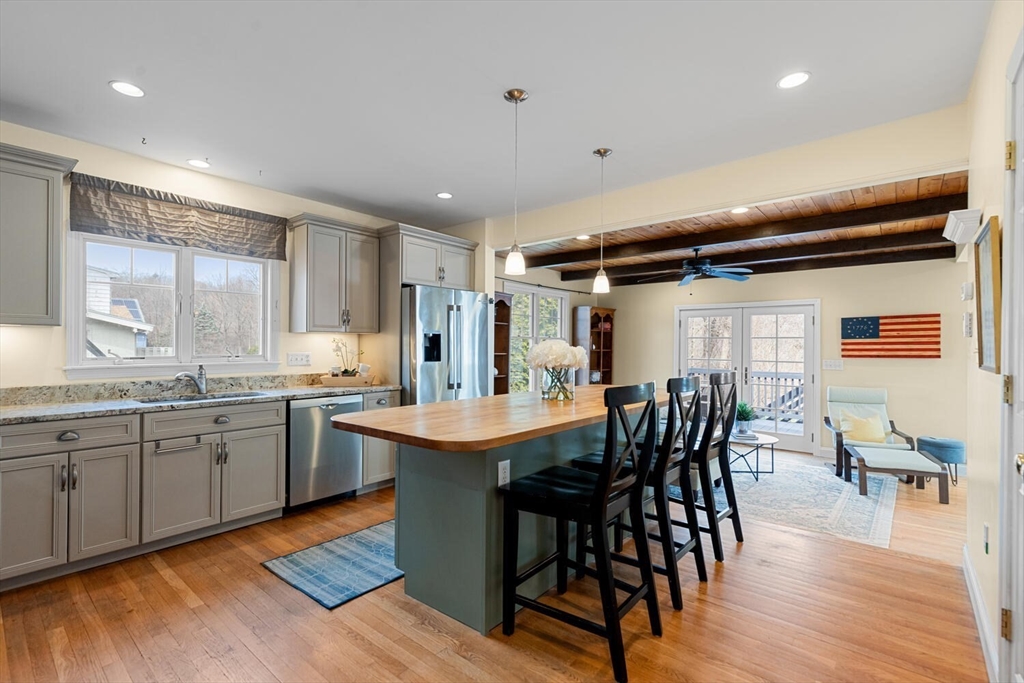 56 Grapevine Avenue Lexington, MA 02421 - Photo 12 of 38 a kitchen with granite countertop a dining table chairs and white cabinets