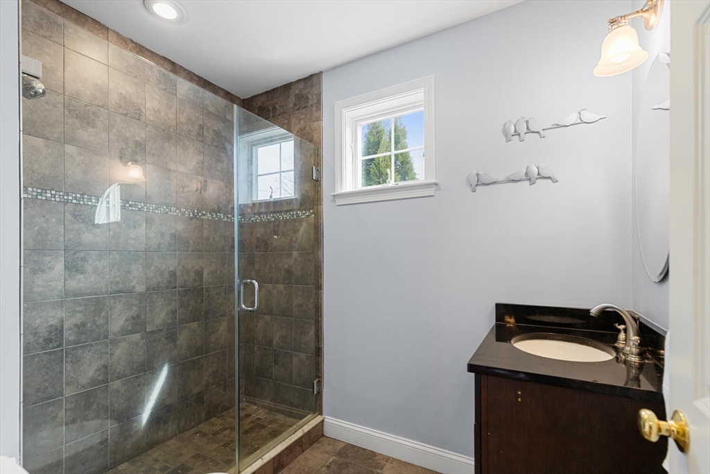 56 Grapevine Avenue Lexington, MA 02421 - Photo 23 of 38 a bathroom with a granite countertop sink a mirror and a shower