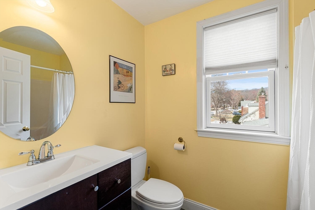 56 Grapevine Avenue Lexington, MA 02421 - Photo 32 of 38 a bathroom with a toilet a sink a mirror a vanity and a window