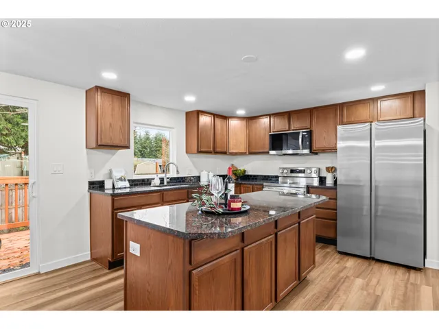a kitchen with stainless steel appliances granite countertop a sink refrigerator and microwave