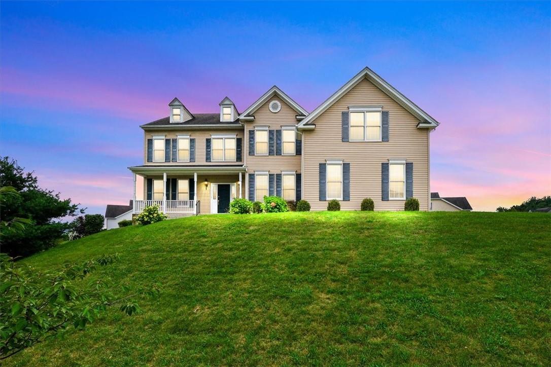 a front view of a house with a yard and trees