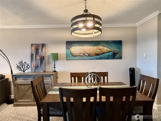 a living room with furniture a chandelier and a dining table