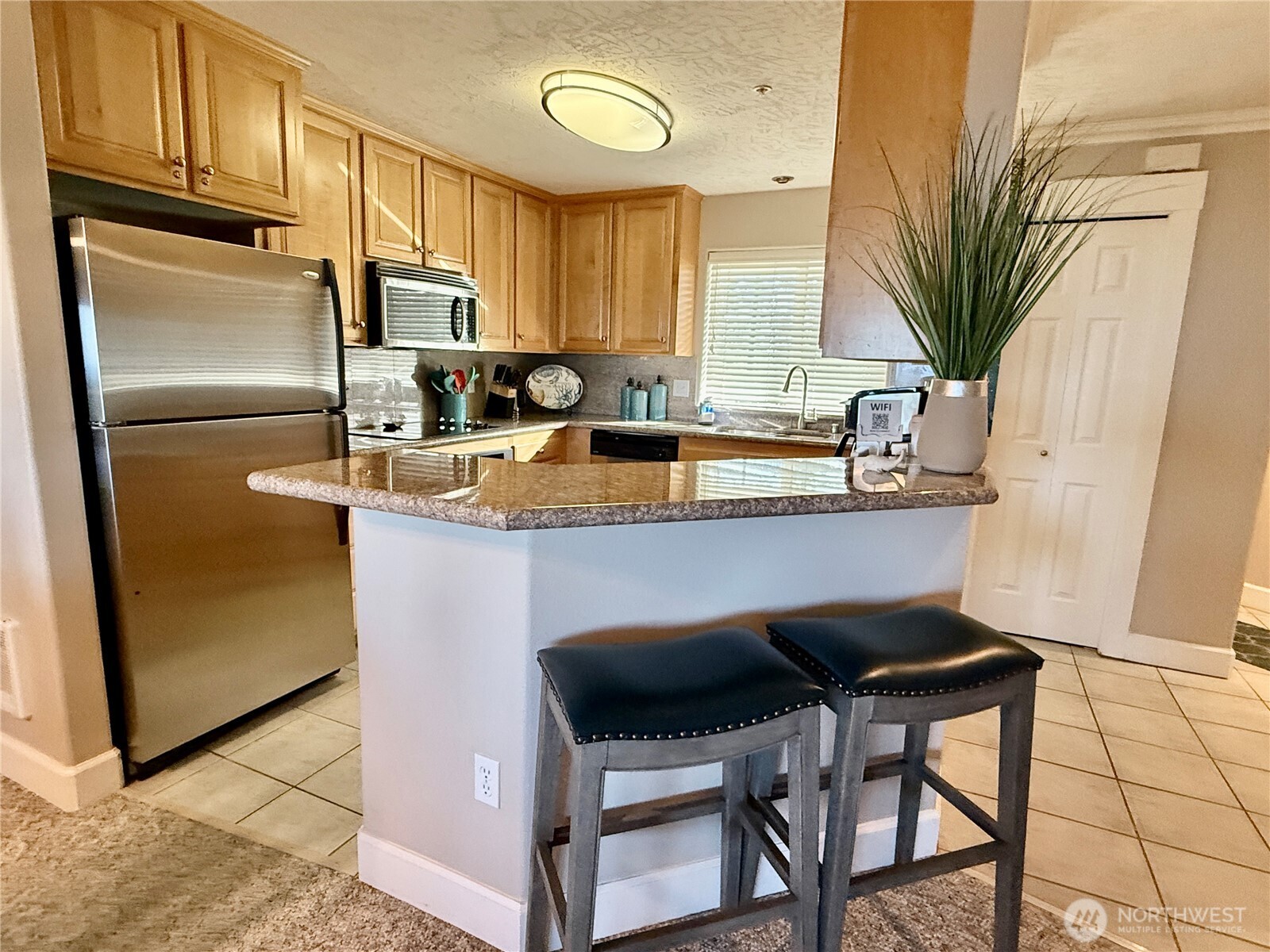 2815 Willows Road, Unit 210 Seaview, WA 98644 - Photo 16 of 35 a kitchen with stainless steel appliances a sink a stove a refrigerator cabinets and a dining table