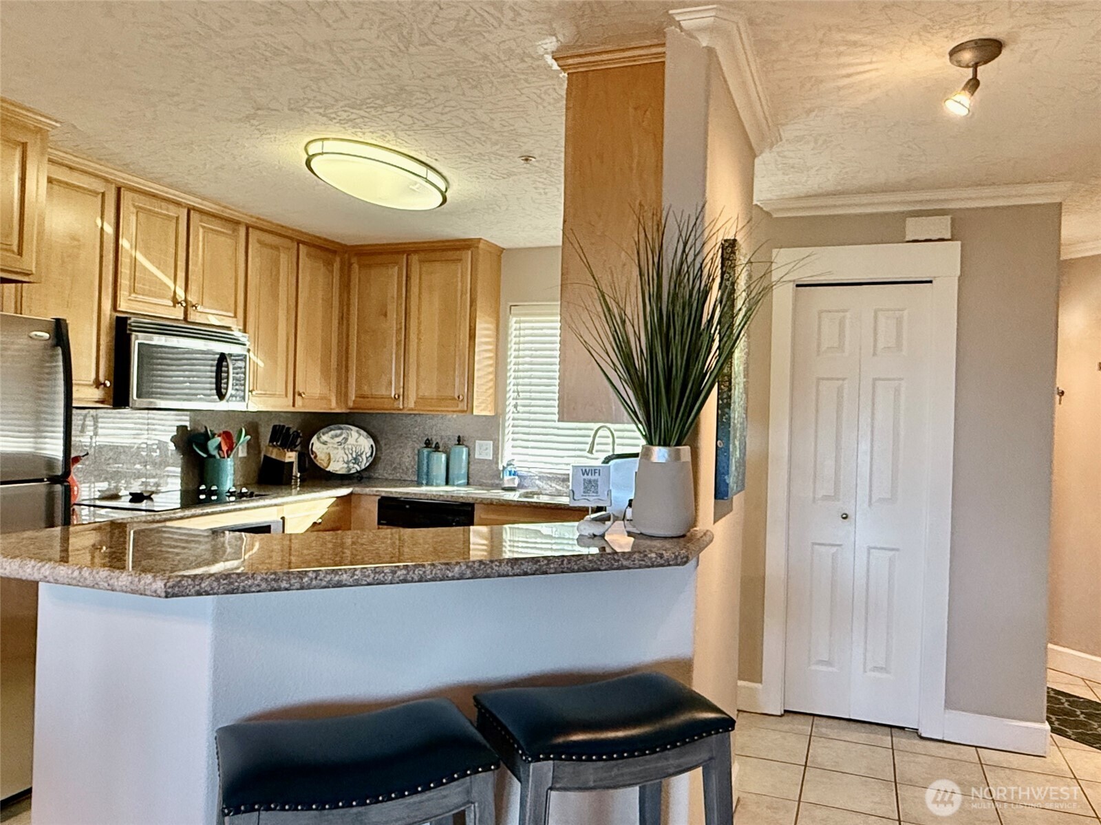 2815 Willows Road, Unit 210 Seaview, WA 98644 - Photo 17 of 35 a kitchen with stainless steel appliances granite countertop a sink a stove cabinets dining table and chairs