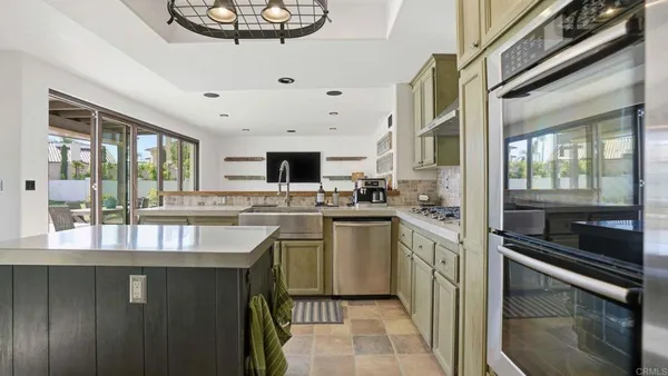 a kitchen with kitchen island granite countertop a stove and a sink
