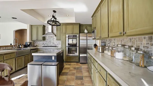 a kitchen with granite countertop a sink stainless steel appliances a counter space and cabinets