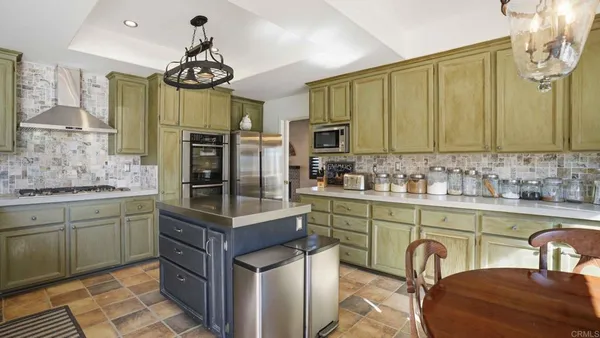 a kitchen with stainless steel appliances granite countertop a stove a sink and a refrigerator