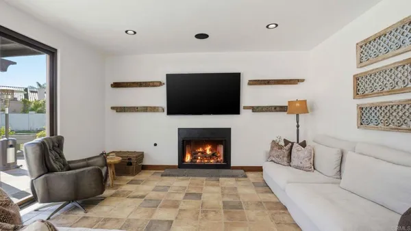 a living room with furniture a flat screen tv and a fireplace