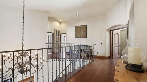 a view of a hallway with wooden floor and windows